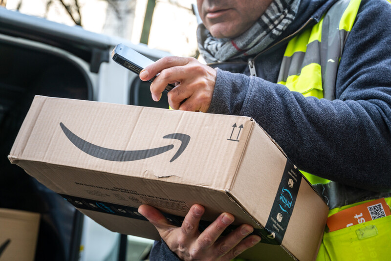 a man holding an amazon package for delivery