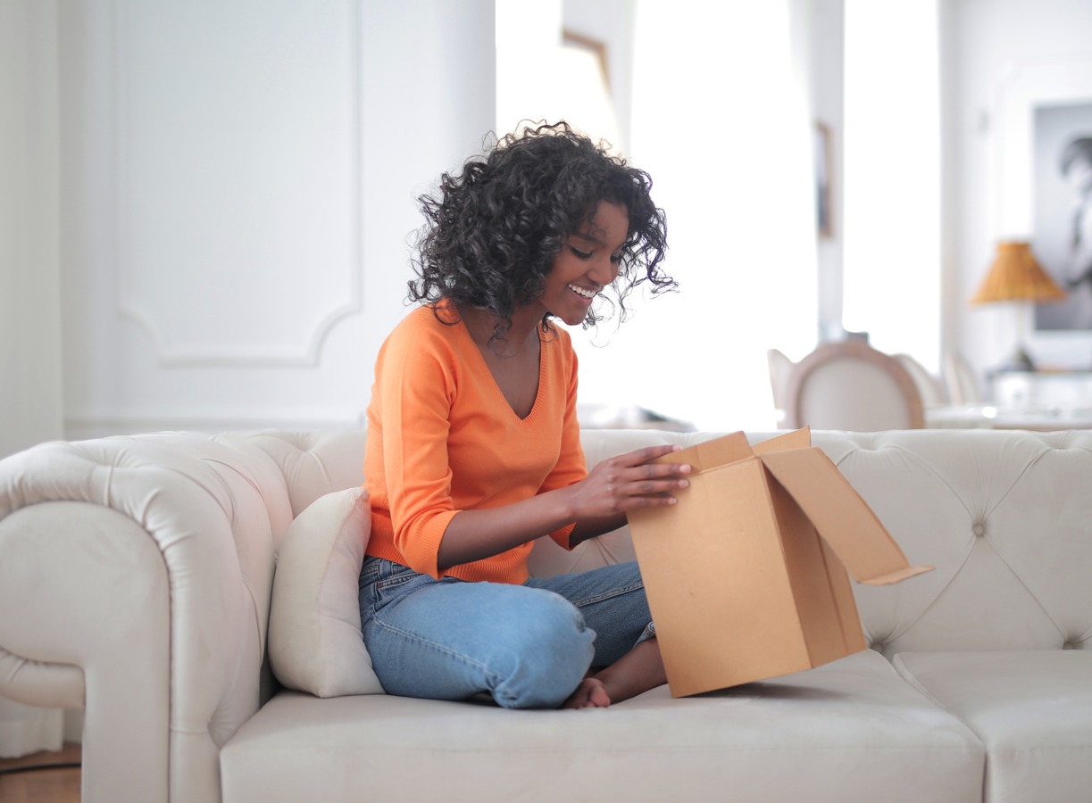 a woman smiling while unpacking a package