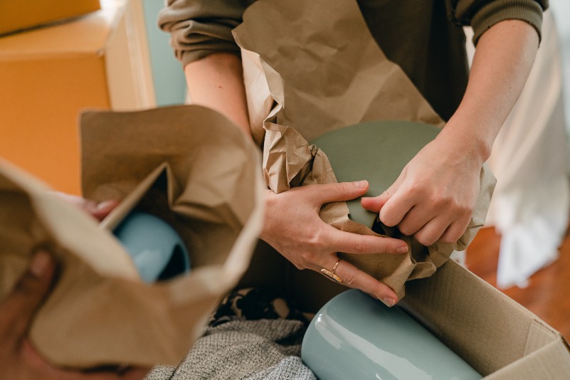 closeup shot of a person individually wrapping their items with paper